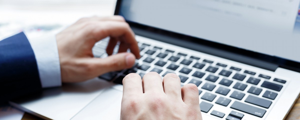 close up view of businessman typing on laptop indoors